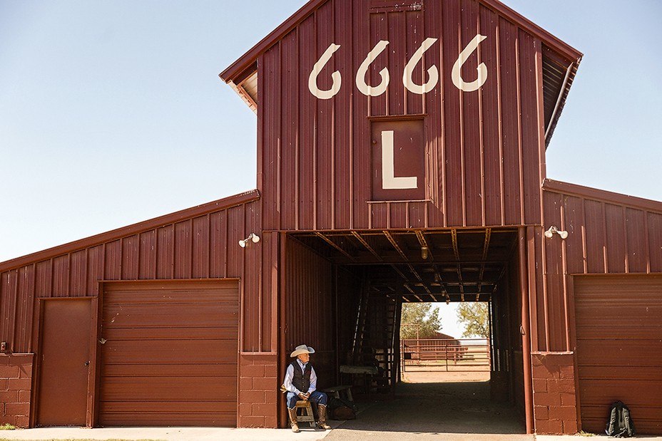 Barn and worker on the set of the 6666 ranch.